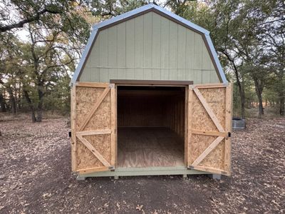 Barn shed: Sage siding with brown trim and double doors.