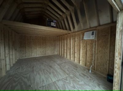 Inside a barn shed with a loft and a window AC unit