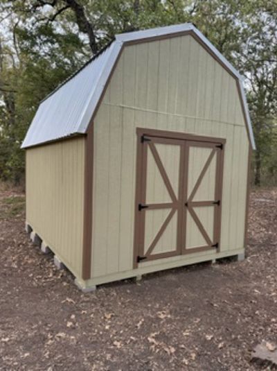 Green barn shed with brown X-braced double doors