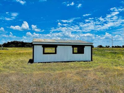 Back of a loafing shed with reddish-brown trim