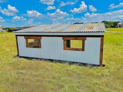 Back of a loafing shed with stained window frames and a corrugated roof