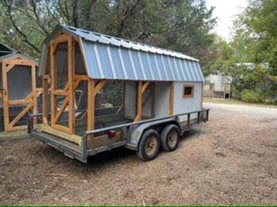 Natural wood and gray coop loaded on a trailer