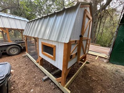 White & natural barn coop: Raised henhouse, natural-stained timber frame and a silver metal roof.